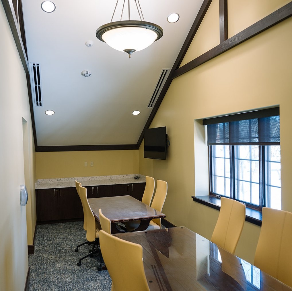  a small meeting room with long tables and a window