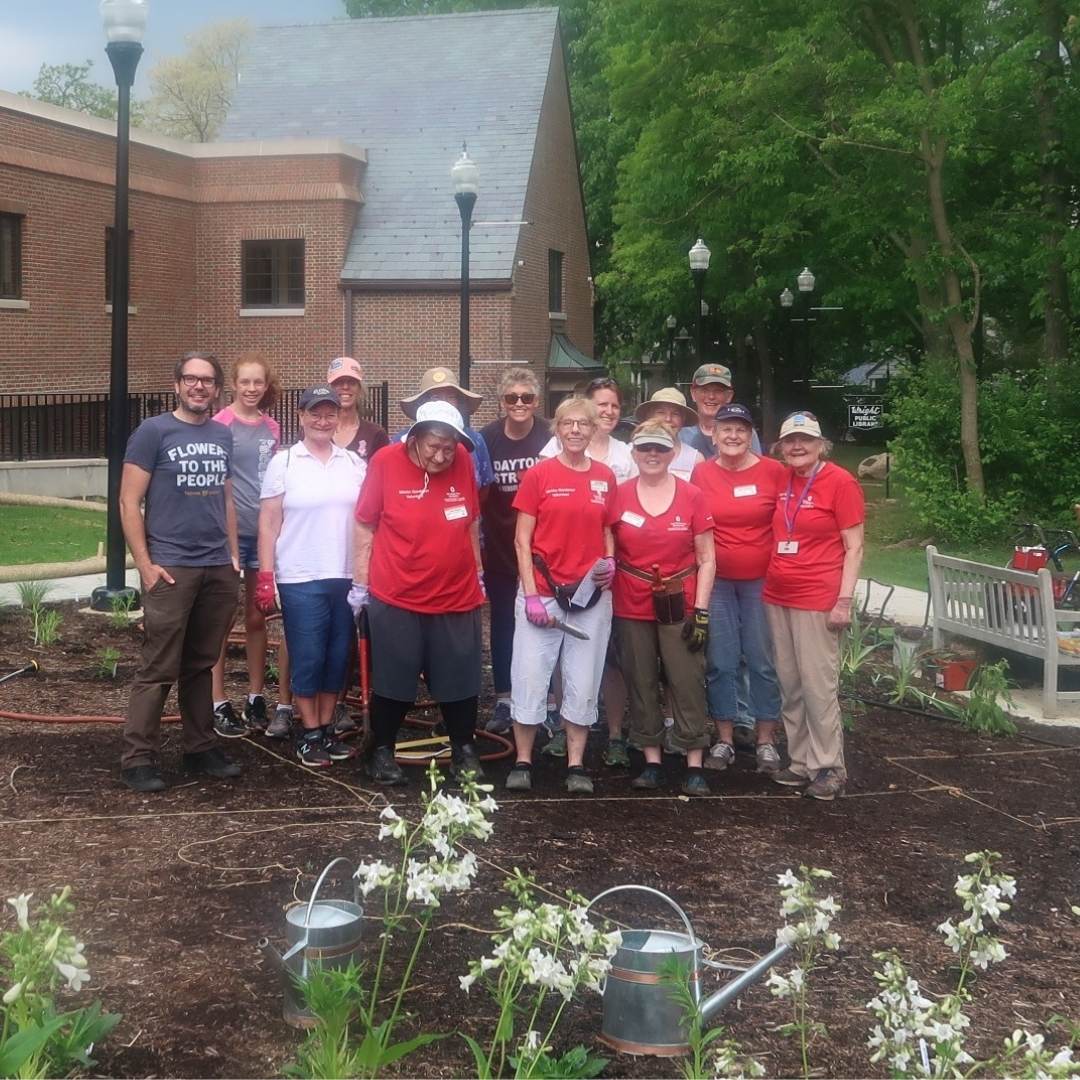 A group of volunteers stand in the Pollinator Garden