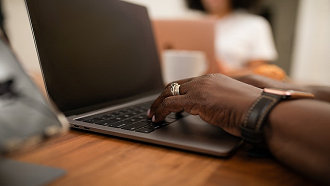 a person's hands type on a laptop computer