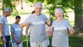 Two seniors proudly wearing "volunteer" t-shirts
