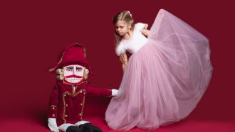 Child ballerina bows to Nutcracker doll