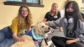 Teens pet a service dog during a Teen Exam Break at Wright Library.