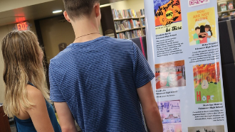 2 teens look at poster exhibit