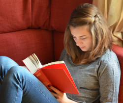 Woman reading book on sofa